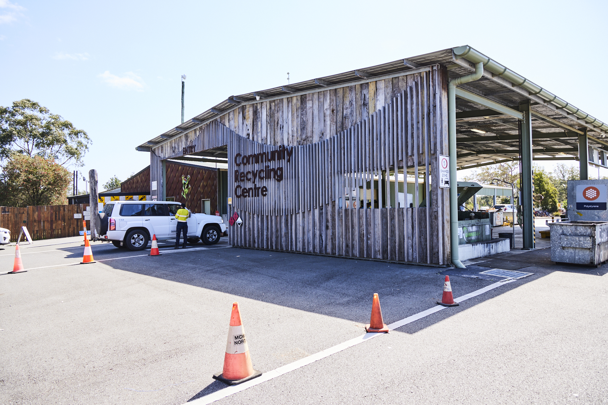 Man Using Measuring Tape in Factory Setting Man Using Measuring Tape in Factory Setting