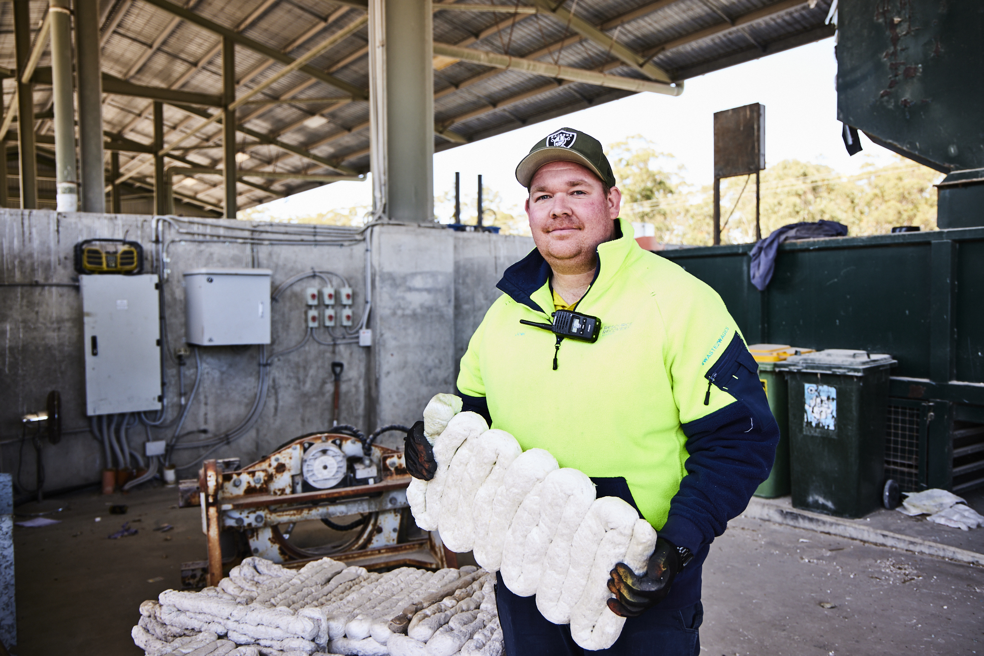 Man Using Measuring Tape in Factory Setting Man Using Measuring Tape in Factory Setting
